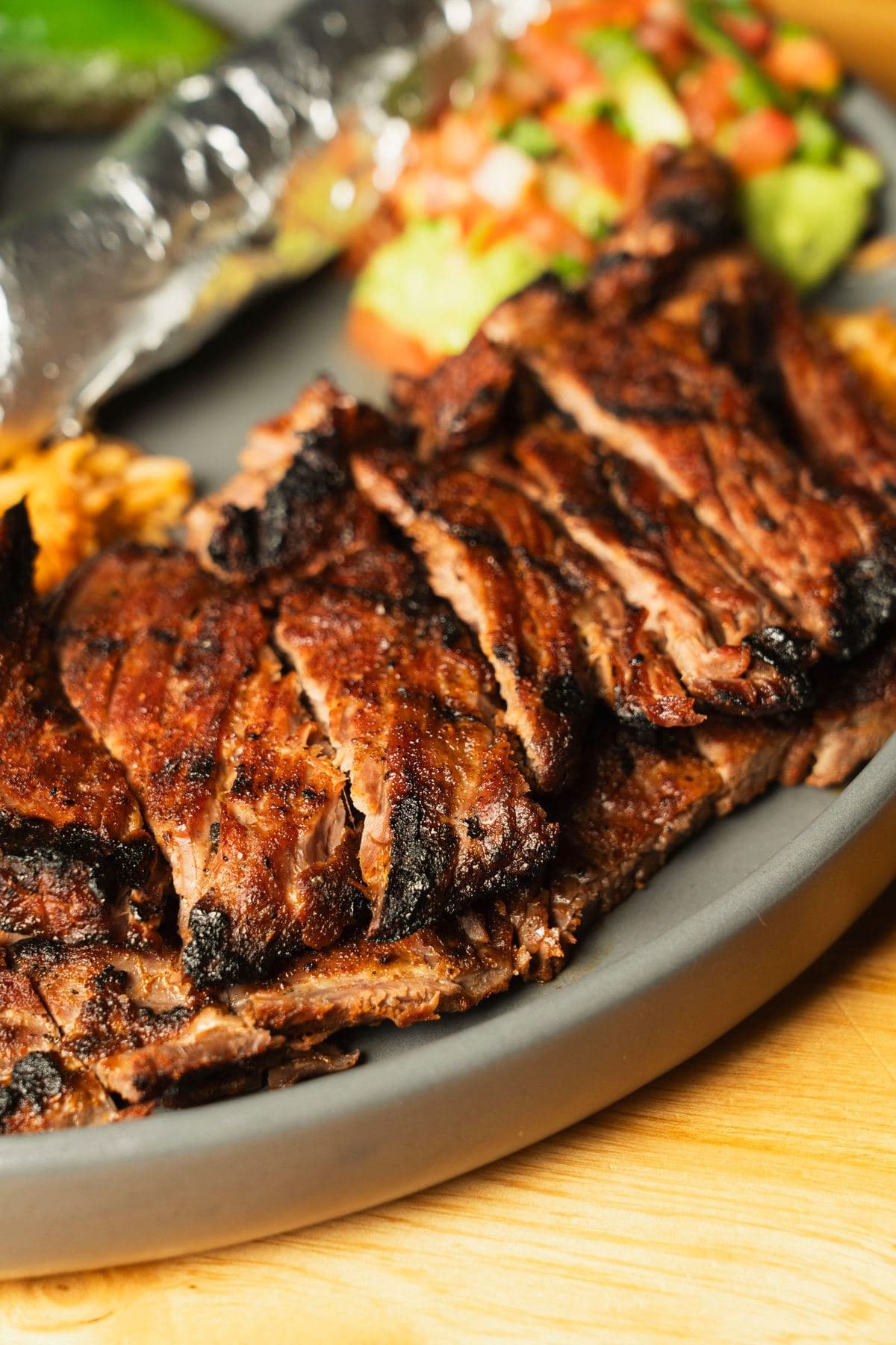 Char-grilled carne asada sliced on a platter