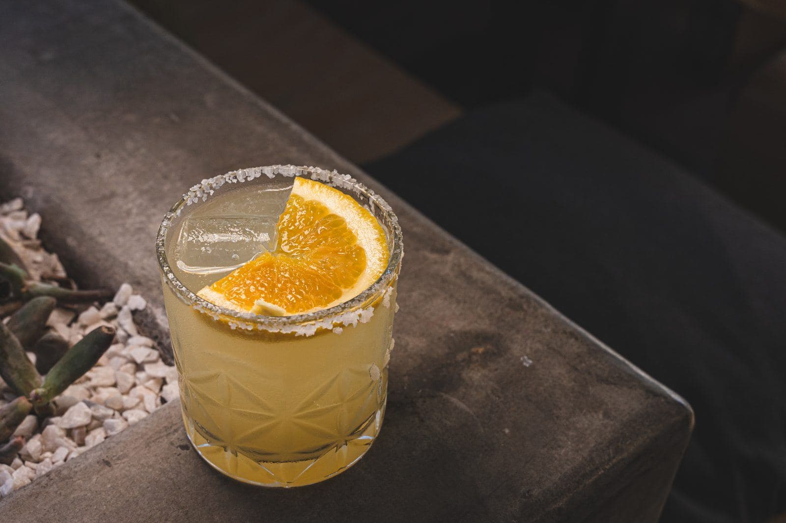 Casero Margarita on the rocks with an orange wheel and salted rim