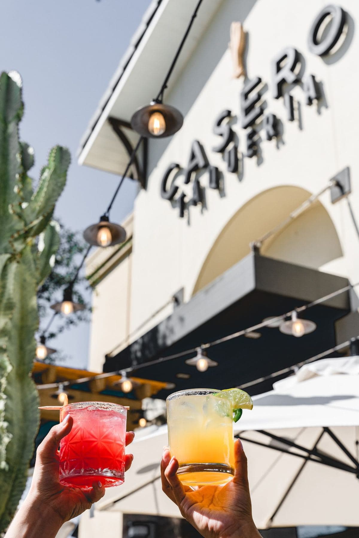 Cocktails raised in front of the Casero Taqueria sign in Bressi Ranch, Carlsbad