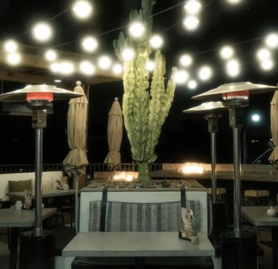 Casero's patio at night with string lights and heaters