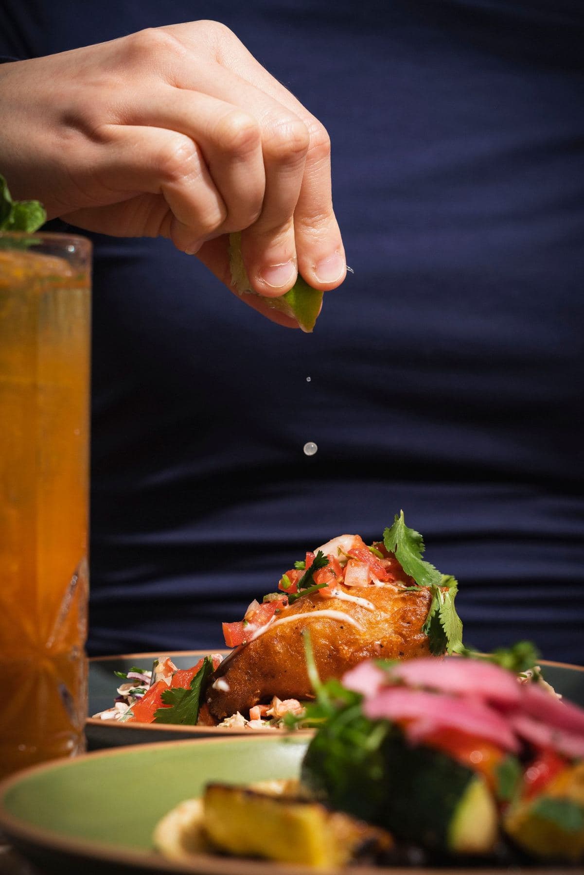 Squeezing fresh lime over a plate of tacos