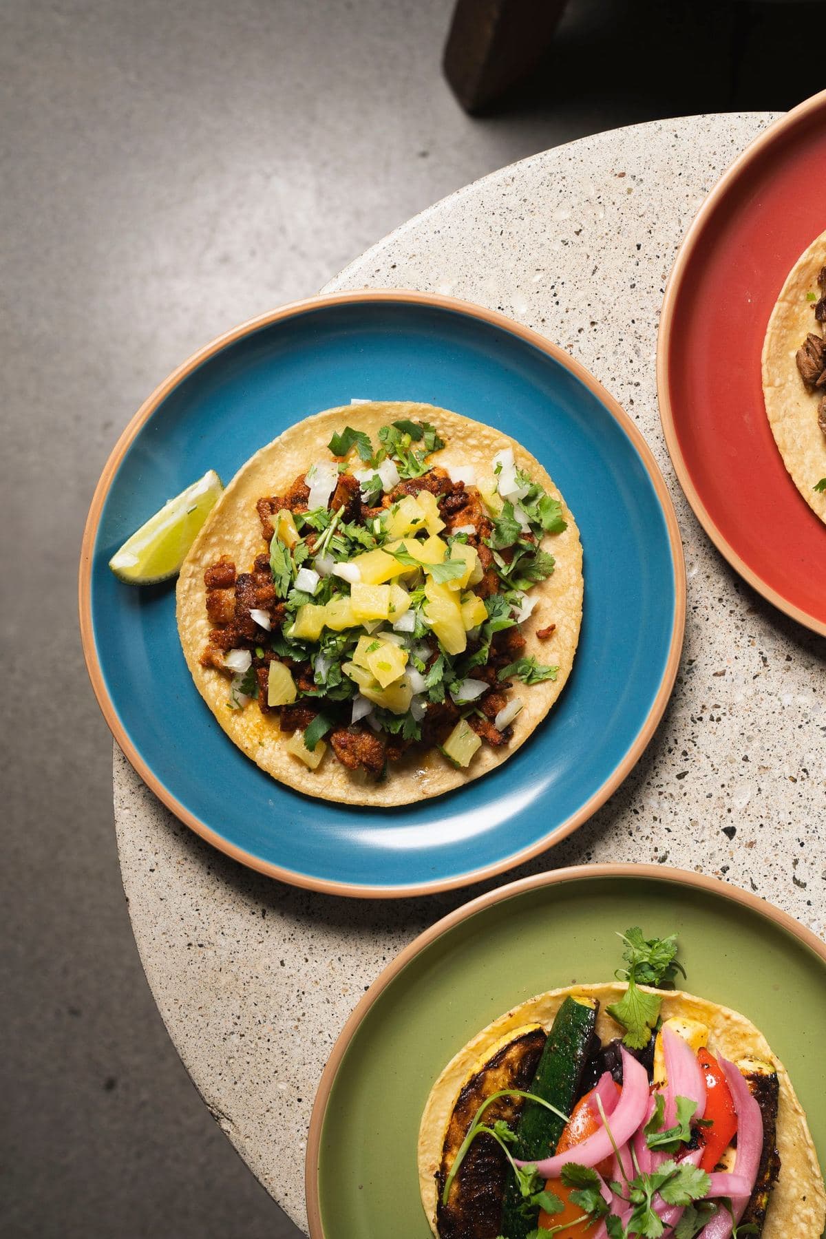 Assorted street tacos served on colorful ceramic plates
