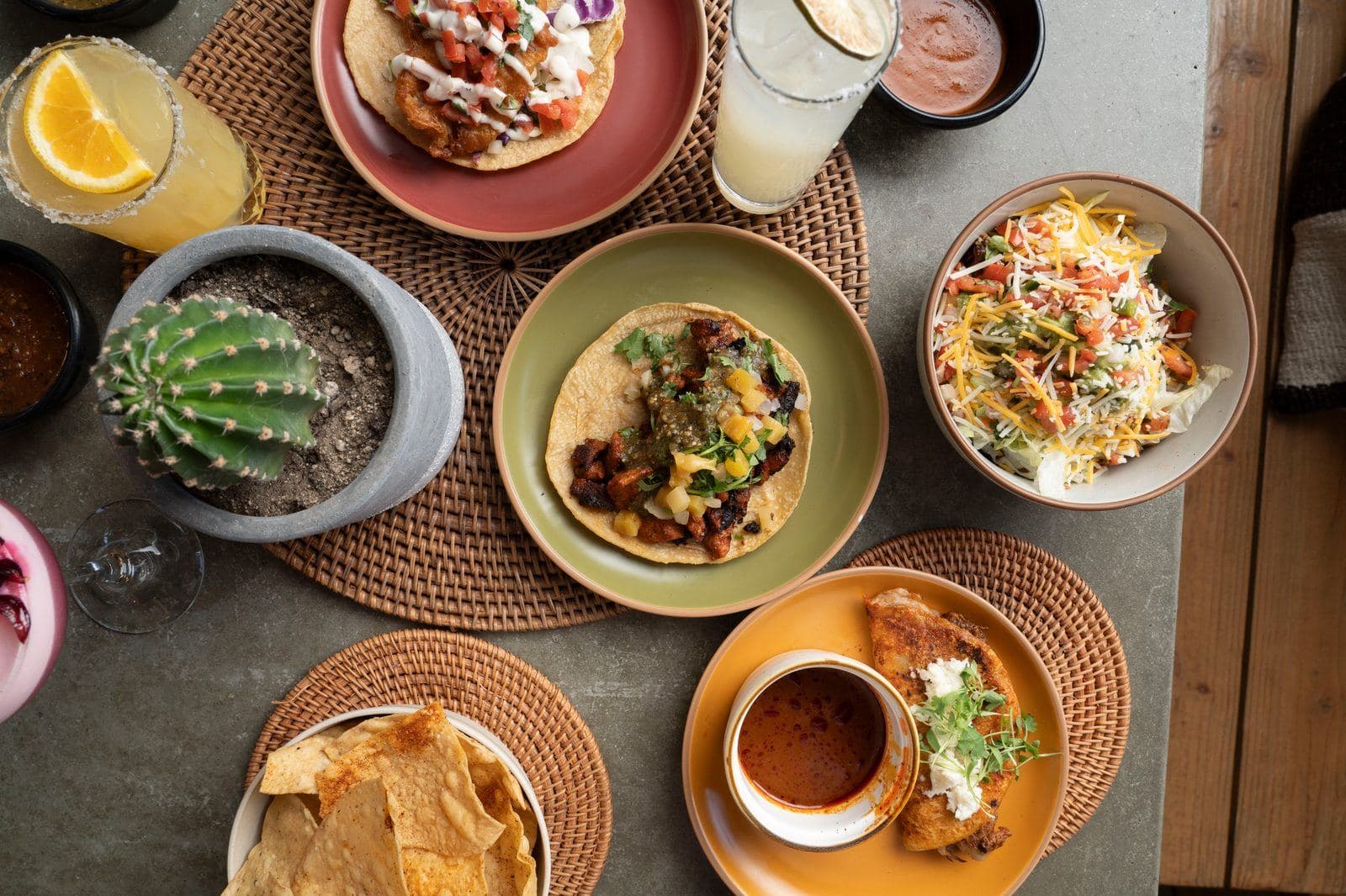Overhead view of tacos, chips, salsa and drinks on a table