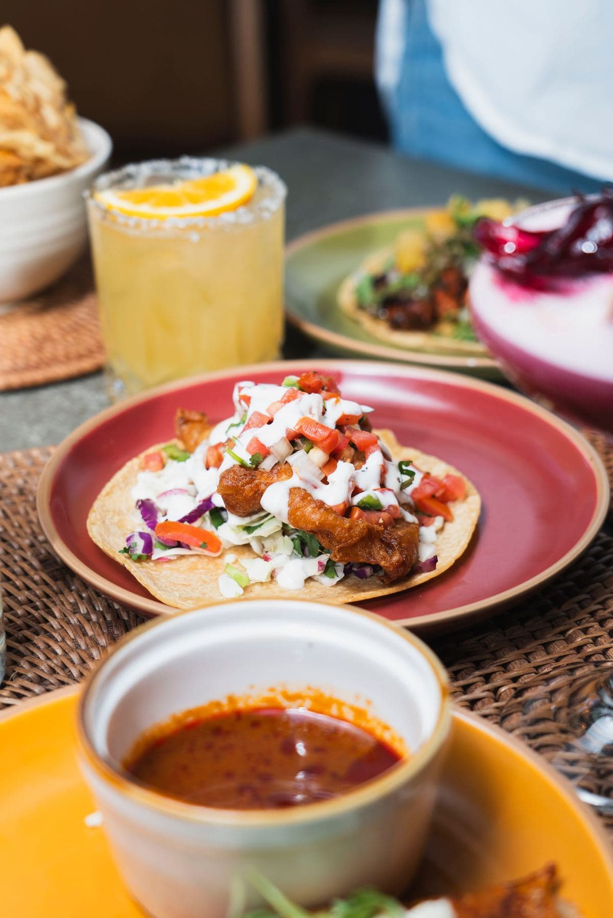 Tacos, consomé and a margarita on the table