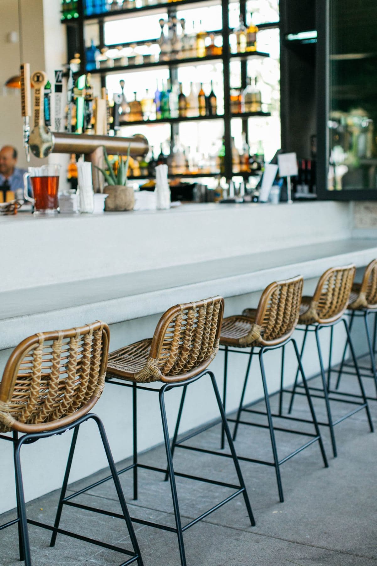 Casero's bar with rattan stools and backlit shelves