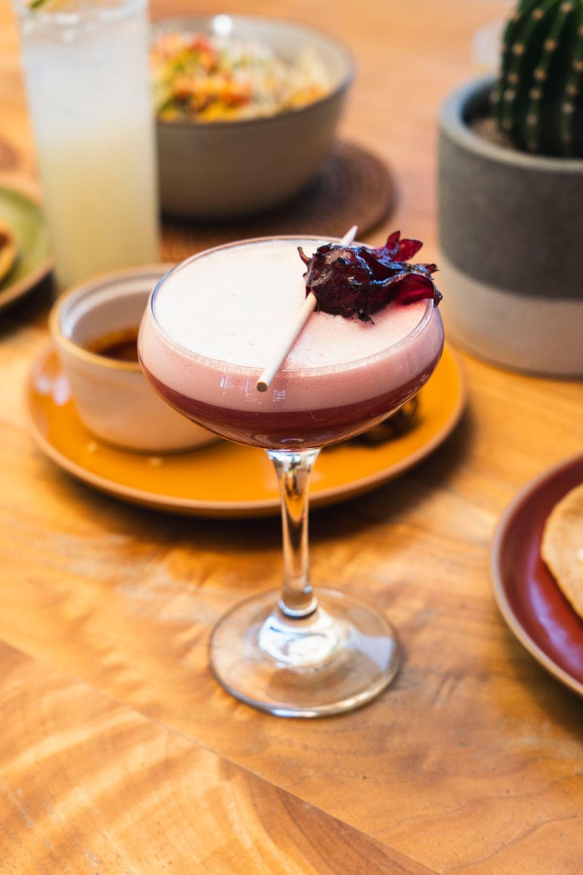 Hibiscus Mistress cocktail with egg-white foam and candied hibiscus