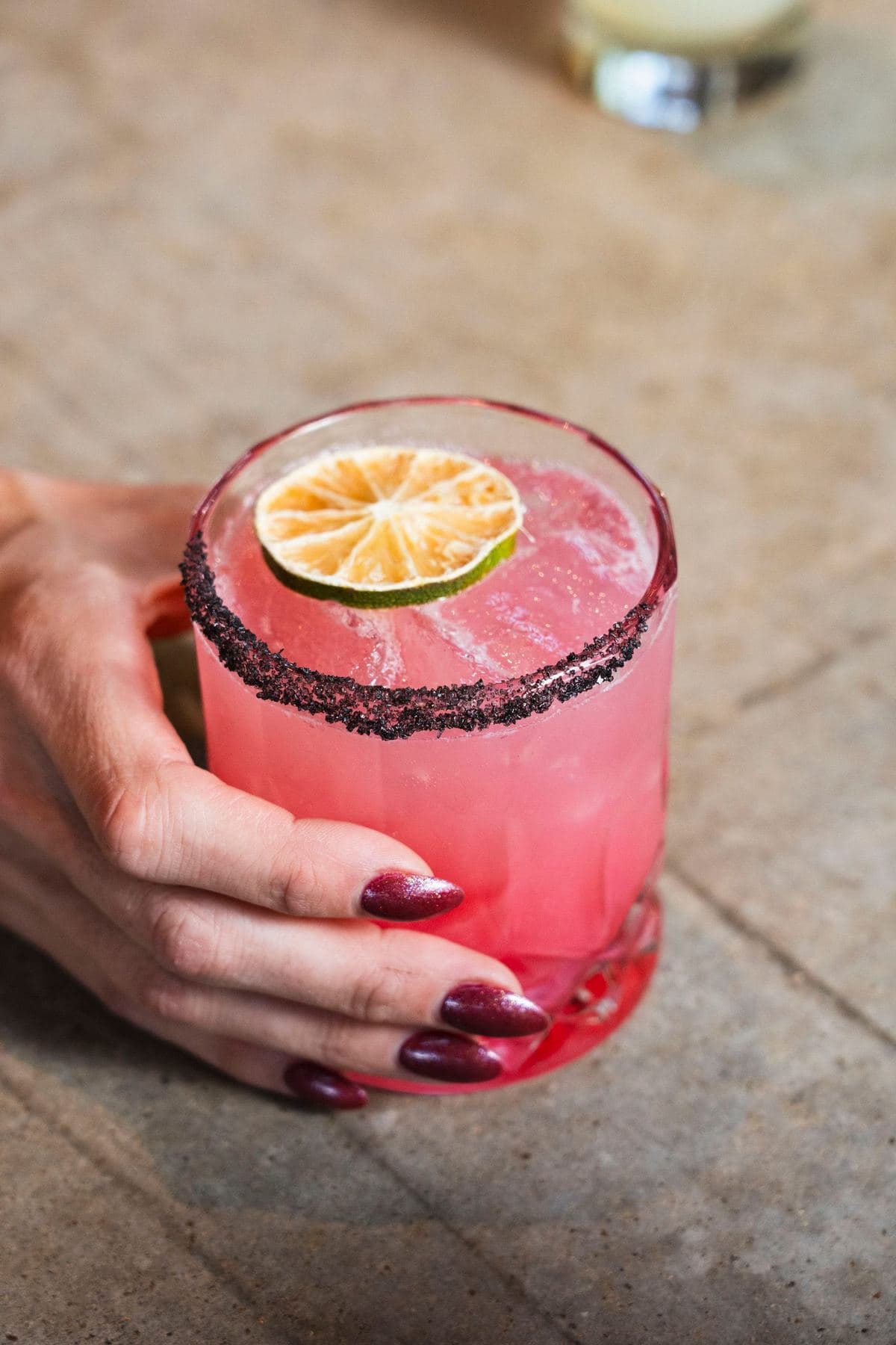 Pink margarita with a chile-salt rim and a dried lime wheel